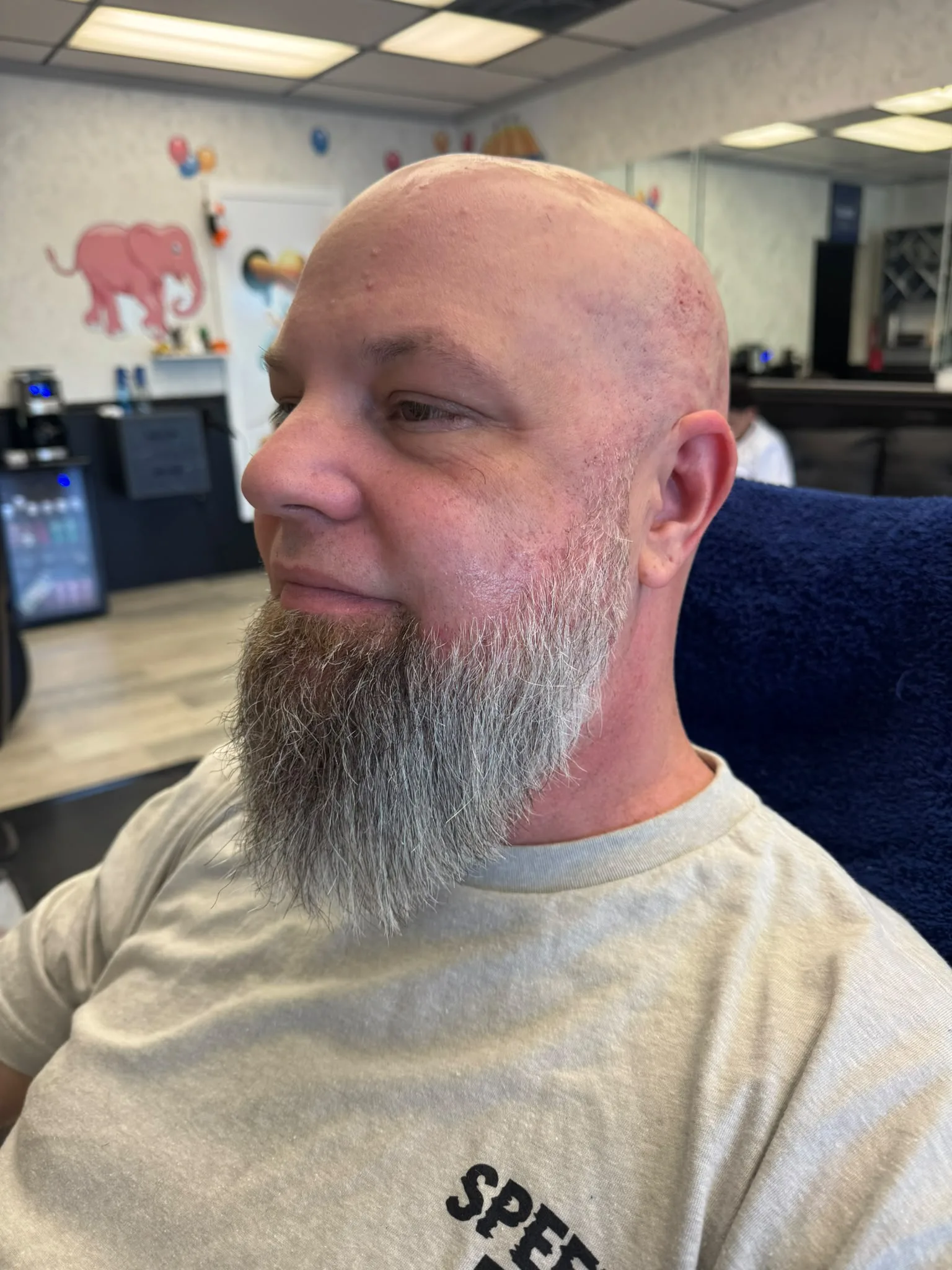Barber giving a beard cut and hair cut combination styling