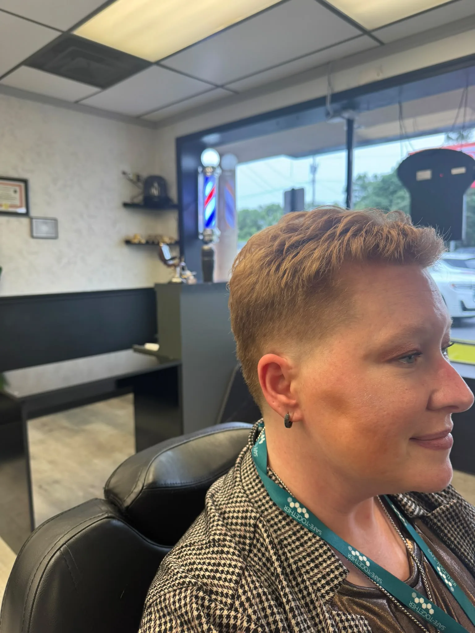 Barber styling a short haircut on a woman client